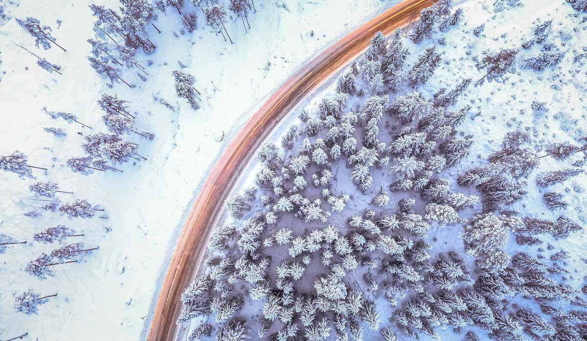 aerial photo of snowy forest and road.