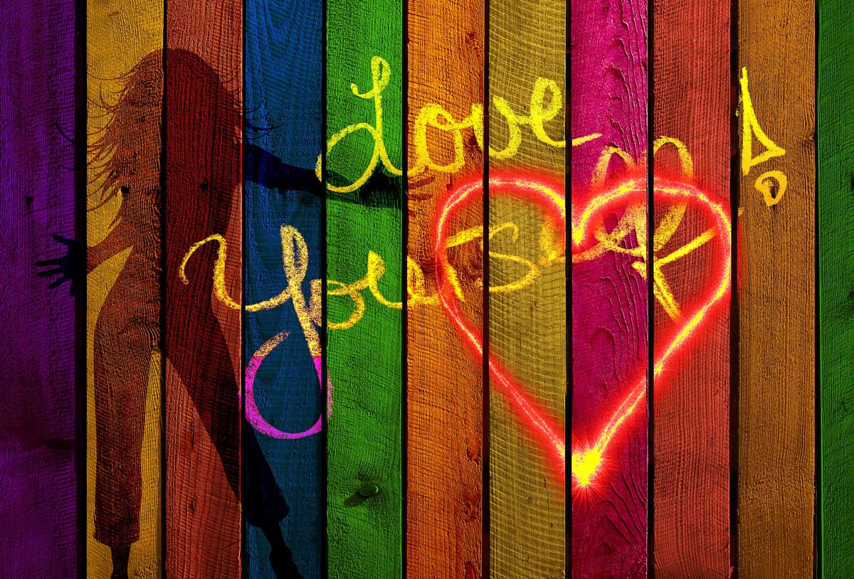 colorful wall says love yourself in chalk writing.