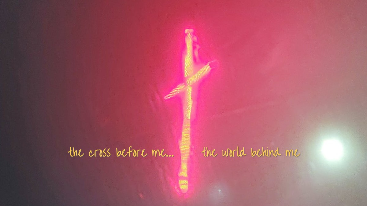 glowing artistic cross in yellow and fuchsia with lyrics, The cross before me, The world behind me.