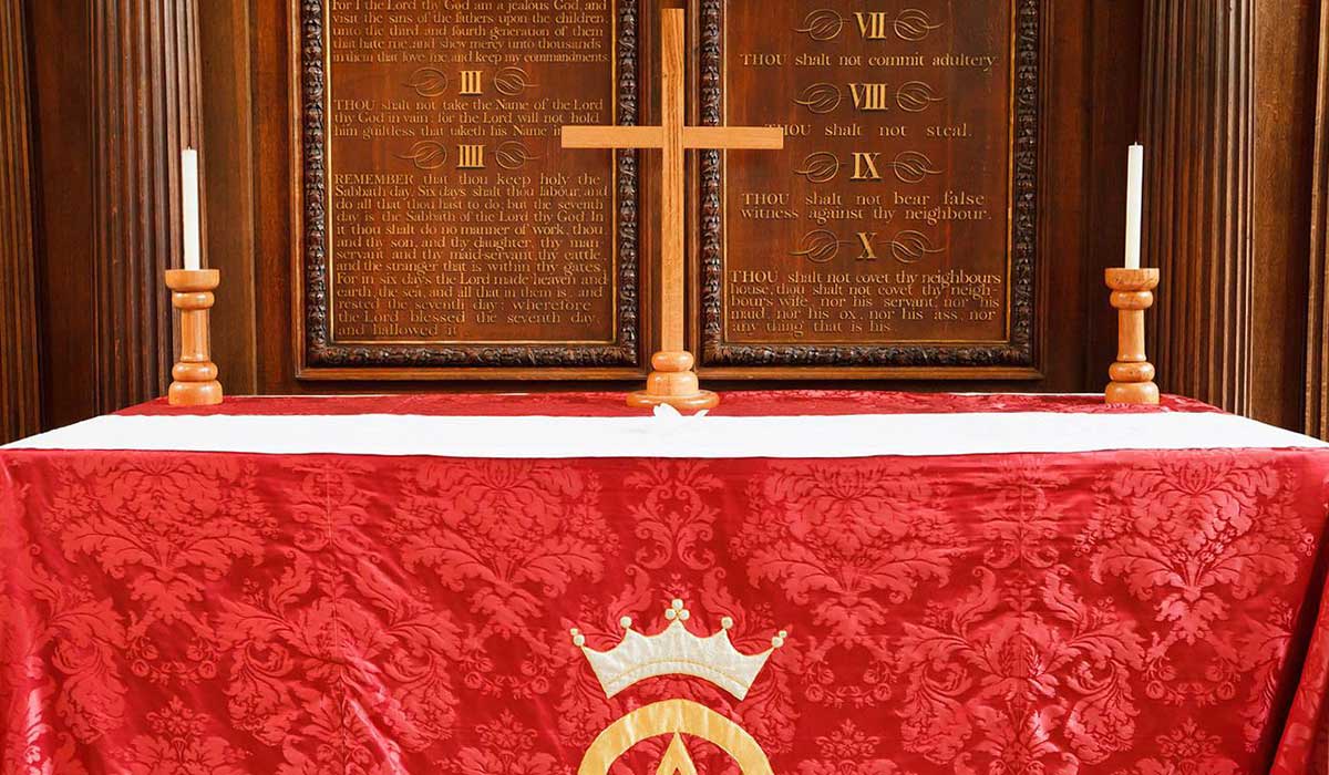 altar with red covering and cross in church.