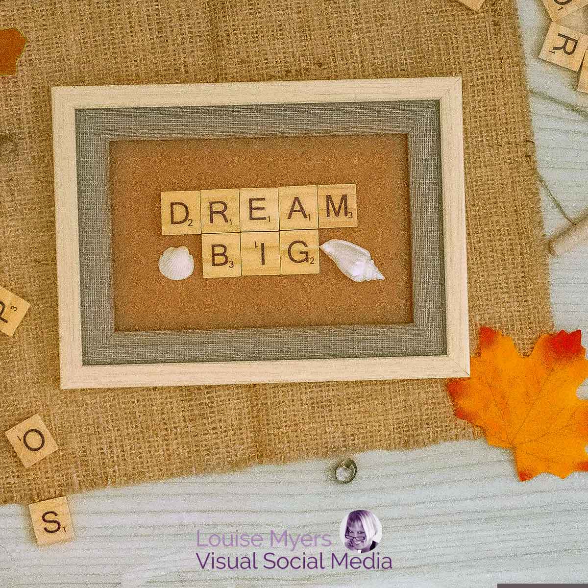 letterboard on burlap with autumn leaves says dream big.