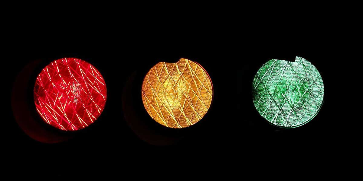 traffic light glows in red, amber and green.