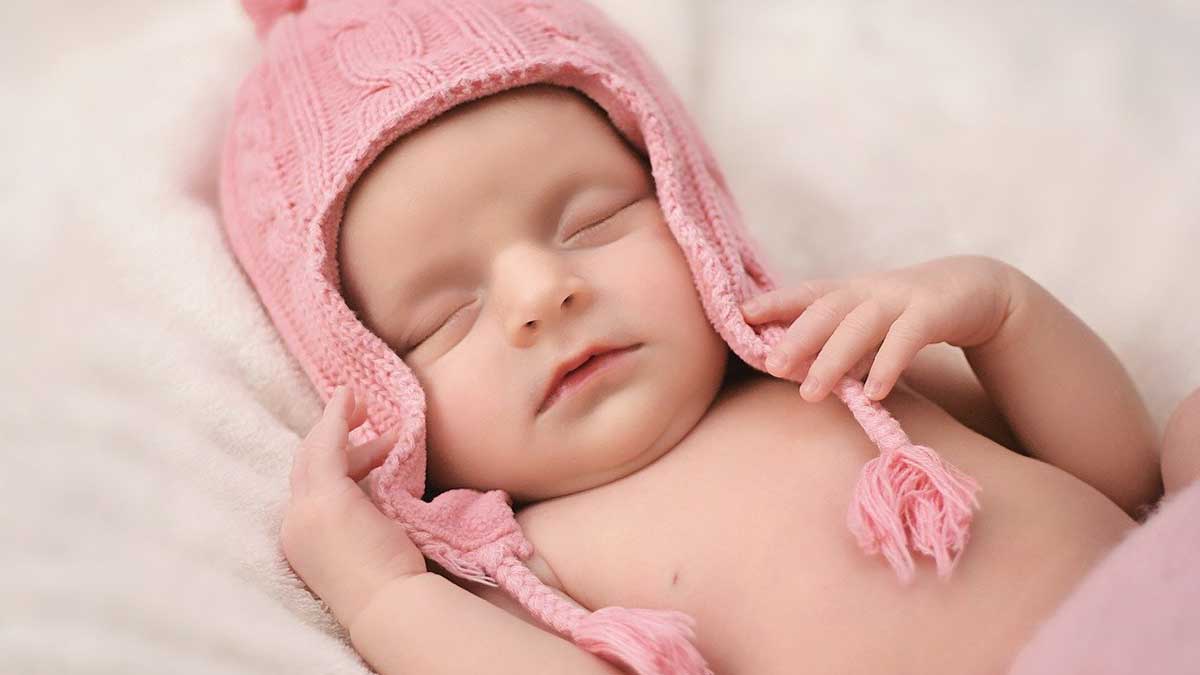 newborn baby girl wearing pink hat.