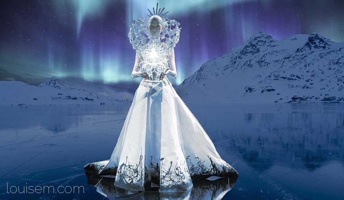 beautiful ice queen stands out in white dress against steely blue background.