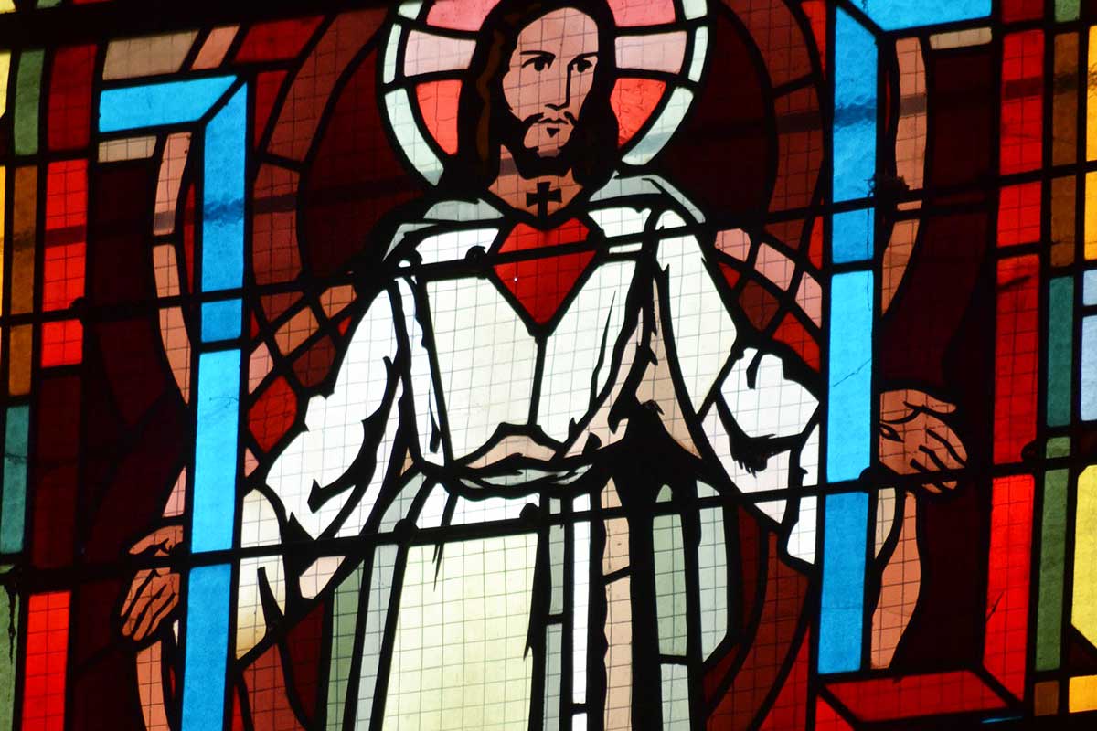 stained glass window with Jesus dressed in bright white.
